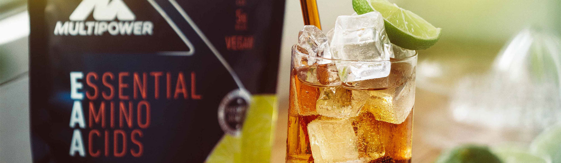 Multipower EAA Pulver und daneben ein Glas Eistee