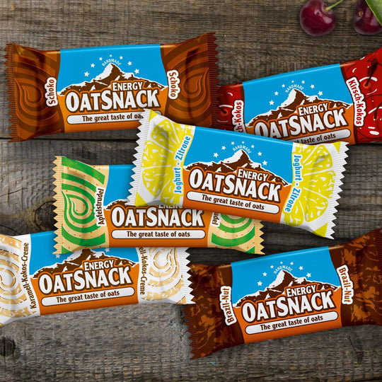 6 Sorten von Davina Oatsnack Haferriegel auf einem Holztisch.